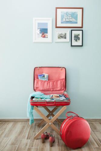 a red suitcase sitting on a stool in a room at 7 Brothers Hotel in Poros