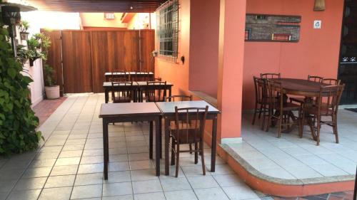 a restaurant with tables and chairs on a patio at Pousada Bartrô in Rio das Ostras