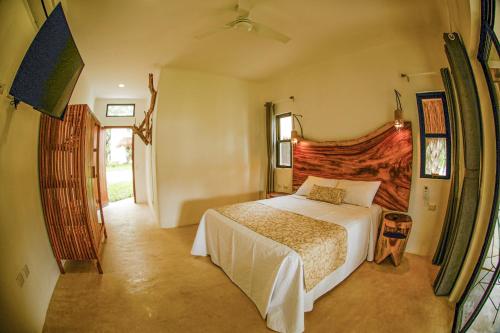 a bedroom with a bed and a dresser at Mi Kasa Tu Kasa Bacalar by Nah Hotels in Bacalar