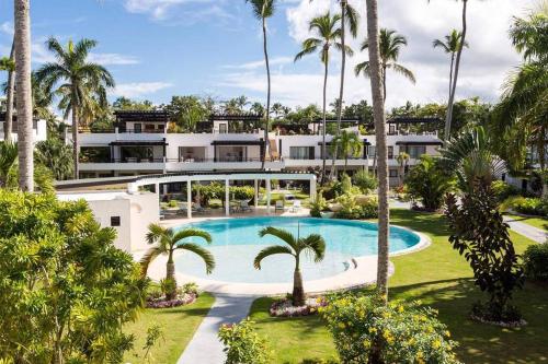 an aerial view of a house with a swimming pool and palm trees at Oasis Apartment C4 inside ALIGIO Residence Hotel in Las Terrenas