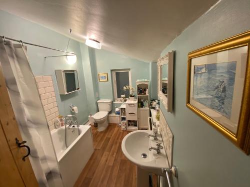 a bathroom with a sink and a shower and a toilet at Prince Cottage in Colchester