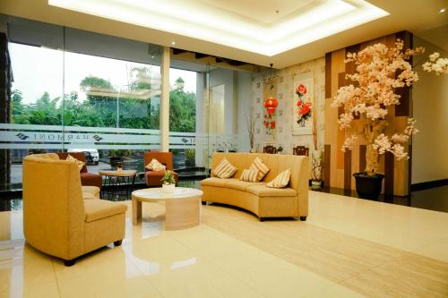 a lobby with couches and chairs in a building at Harmoni Hotel Garut in Garut