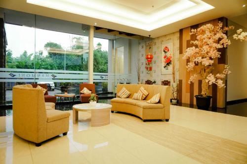 a living room filled with furniture and a large window at Harmoni Hotel Garut in Garut