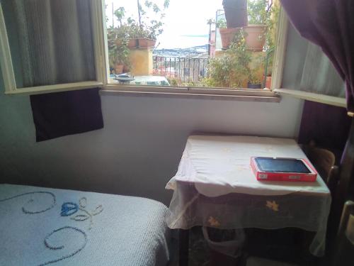 a small table in a room with a window at Large Triple Room for max 3 people in Taormina