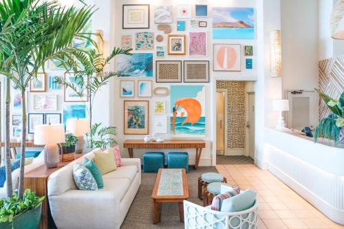 
a living room filled with furniture and plants at Kaimana Beach Hotel in Honolulu
