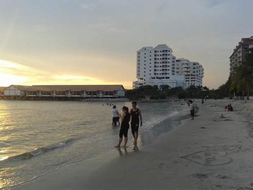 a man and a woman standing on the beach at Wonderland Private Pool Villas at Port Dickson in Port Dickson