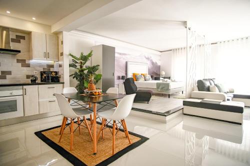 a kitchen and a living room with a table and chairs at Préstige Holidays Alojamentos in Nazaré