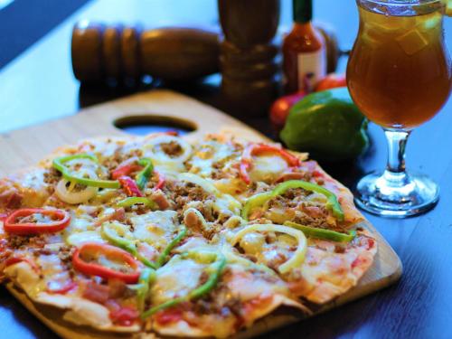a pizza sitting on top of a table next to a drink at One Pacific Place Serviced Residences in Manila