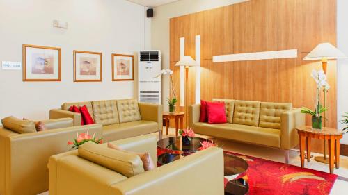 a living room with yellow couches and red pillows at One Pacific Place Serviced Residences in Manila