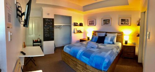 a bedroom with a bed with a blue comforter at WAVE N' SOUL in Dunsborough