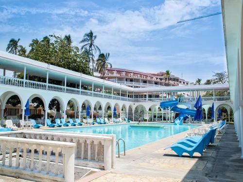 a resort with a swimming pool and a building at Collection O Hotel Mocambo, Boca del Río in Veracruz