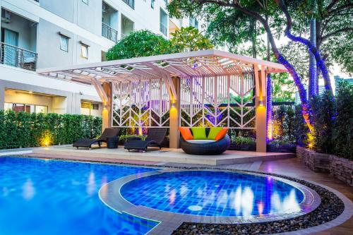 - une piscine avec un kiosque à côté d'un bâtiment dans l'établissement Pacific Park Hotel, à Si Racha