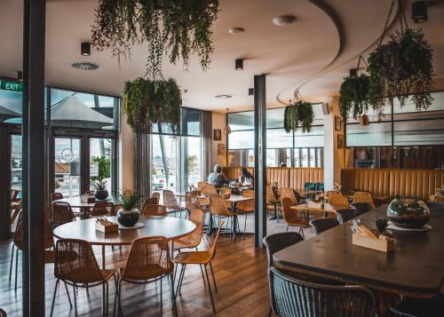 a restaurant with tables and chairs and windows at Shoreline Hotel in Hobart