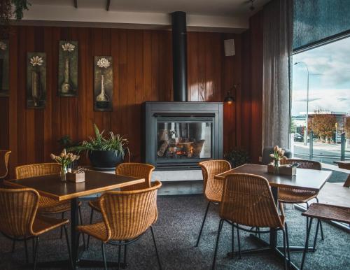 um restaurante com duas mesas e uma lareira em Shoreline Hotel em Hobart