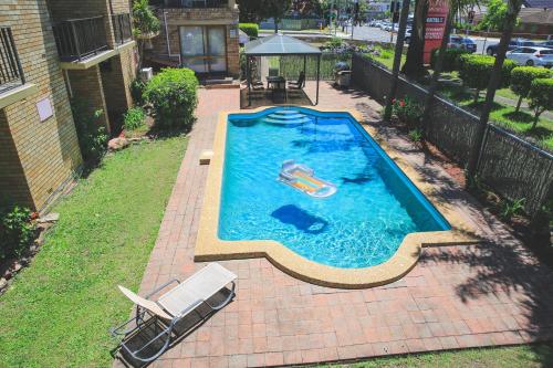 a swimming pool with a float in a backyard at Metro Inn Ryde in Sydney