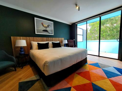 a bedroom with a large bed and a colorful rug at The Blue Hotel Bondi in Sydney