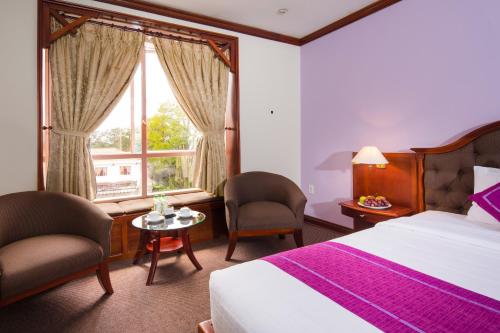 Postel nebo postele na pokoji v ubytování TTC Hotel - Da Lat