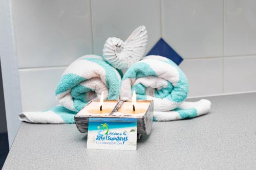 a couple of candles on a counter with towels at Airlie Sun & Sand Accommodation #2 in Airlie Beach