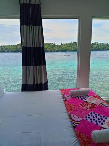 a bedroom with a bed and a view of the water at Mr. Bean Resort in Sabong