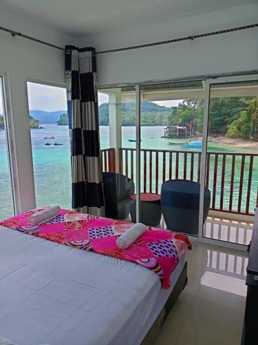 a bedroom with a bed with a view of the water at Mr. Bean Resort in Sabong