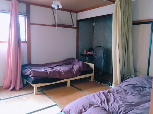 um quarto com 2 camas e uma janela em yado & kissa UGO HUB em Yuzawa