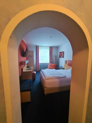 a hotel room with a bed and an archway at Hotel Silberhorn in Nürnberg