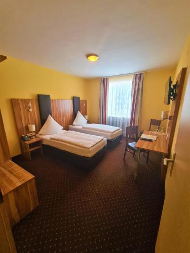 a hotel room with a large bed and a desk at Hotel Silberhorn in Nürnberg