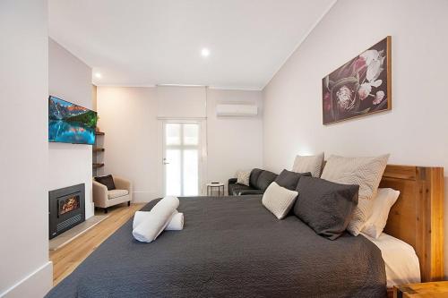 a bedroom with a large bed and a living room at Little Hopwood Apartment No1 in Echuca