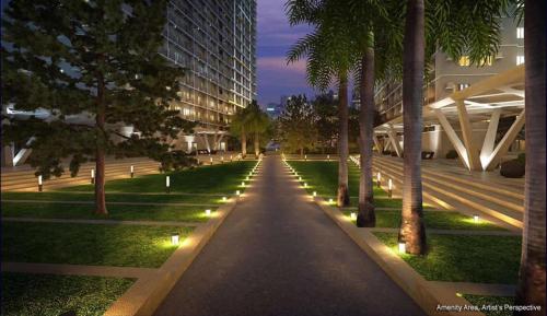 una pasarela en un parque con árboles y luces en Fame Residences T1 Family Suite 1507 en Manila