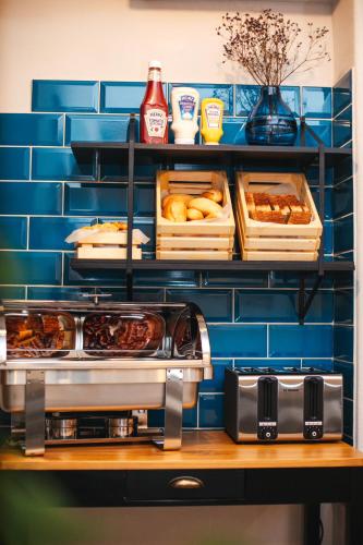 a blue tiled kitchen with a counter with food at CASA HINTZ Transilvania in Făgăraş
