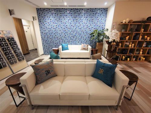 a living room with a white couch in a store at Green Rich Hotel Miyazaki Tachibandori 2 (Artificial hot spring Futamata Yunohana) in Miyazaki