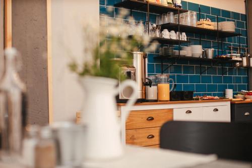 a kitchen with blue tile on the wall and a table at CASA HINTZ Transilvania in Făgăraş