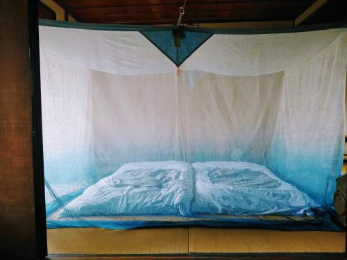 uma cama dentro de uma tenda de plástico em 旧鈴木邸 女性専用 em Matsuyama