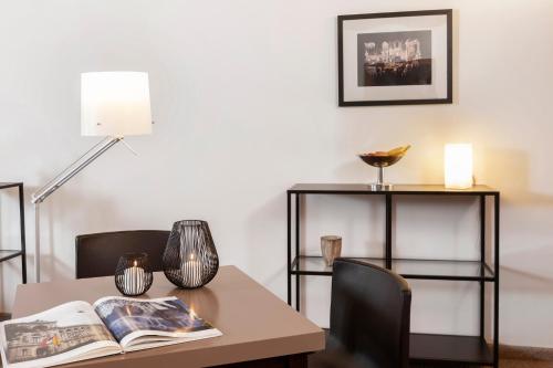 a table with a book and chairs and a lamp at Hotel am Markt in Baden-Baden