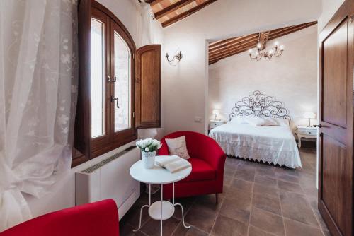 um quarto com uma cadeira vermelha e uma cama em Antica Torre del Borgo em Certaldo