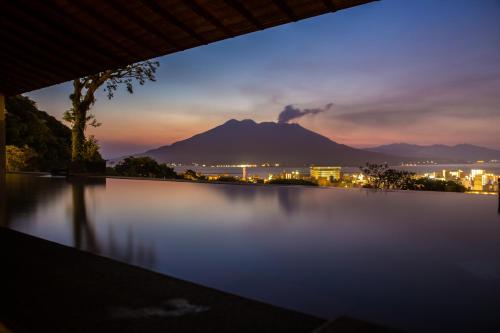 a view of a mountain at night with a body of water at SHIROYAMA HOTEL kagoshima in Kagoshima