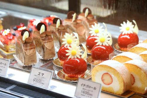 a display of cakes and pastries in a display case at SHIROYAMA HOTEL kagoshima in Kagoshima