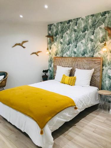 une chambre avec un grand lit avec une couverture jaune dans l'établissement Cocon douillet face à la mer de Cagnes sur mer, à Cagnes-sur-Mer