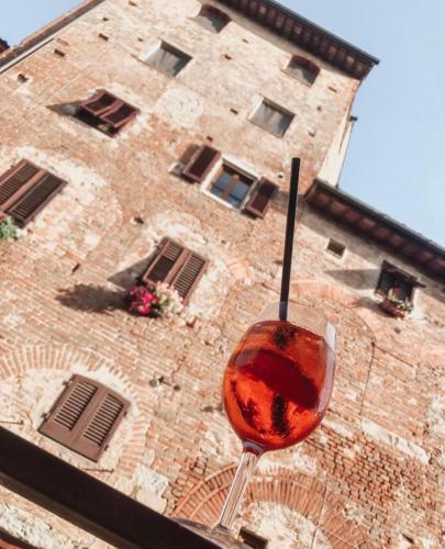a glass of wine sitting in front of a building at Antica Torre del Borgo in Certaldo