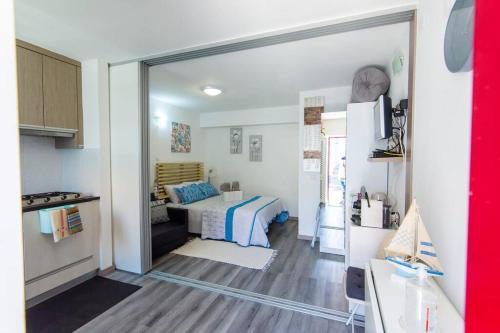 a small bedroom with a bed and a kitchen at GreenEscapes II in Porto Covo