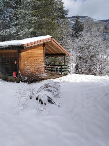 une cabane en bois avec un toit enneigé dans l'établissement chalet du camping la Porte St Martin, à Saint-Martin-en-Vercors