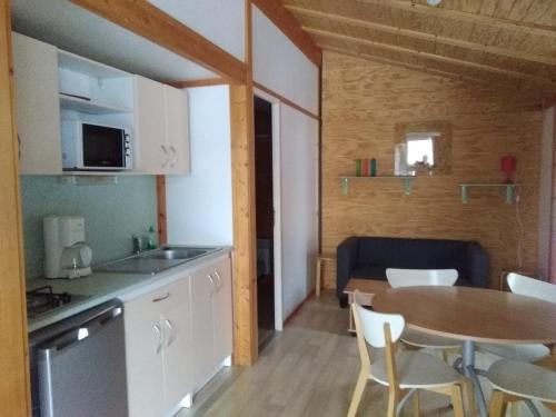 a kitchen and dining room with a table and chairs at chalet du camping la Porte St Martin in Saint-Martin-en-Vercors