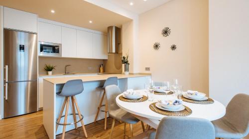 a kitchen and dining room with a white table and chairs at San Martín Suites Apartments in Seville