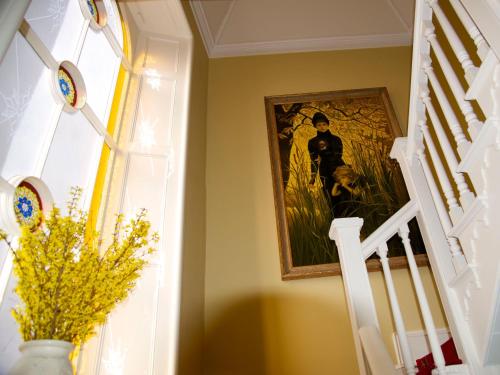 a staircase with a painting on the wall and a vase with flowers at Bay Villa in Grange Over Sands