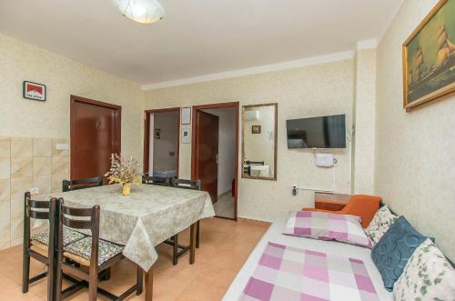 ein Esszimmer mit einem Tisch und einem Sofa in der Unterkunft Apartment Barbara in Batalaži