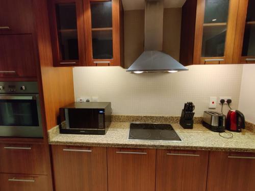 a kitchen with a microwave and a stove top oven at Holiday Homes in Dubai
