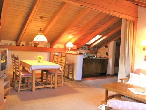 een keuken en een woonkamer met een tafel en stoelen bij Ferienwohnungen Wagner in Ruhpolding