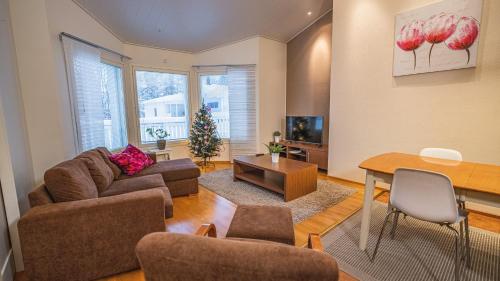 a living room with a couch and a table at Hotel Aakenus Holiday Home Koivu in Rovaniemi