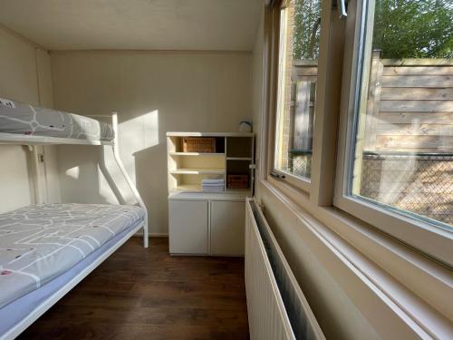 a bedroom with a bunk bed and a window at Rust in Voorthuizen