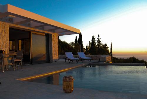 a house with a swimming pool with a table and chairs at Nikolakos Villa in Agios Nikolaos